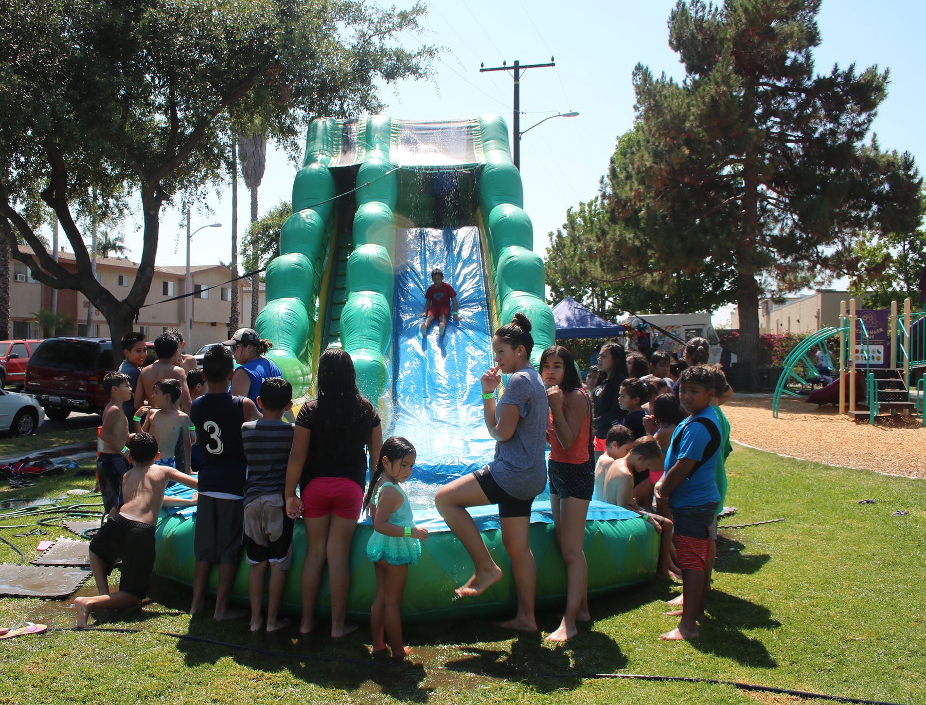 kids sliding down a waterslide with others watching