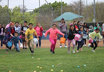 kids running on the grass to find Easter eggs