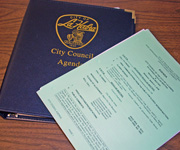City Council Agenda notebook with papers on top