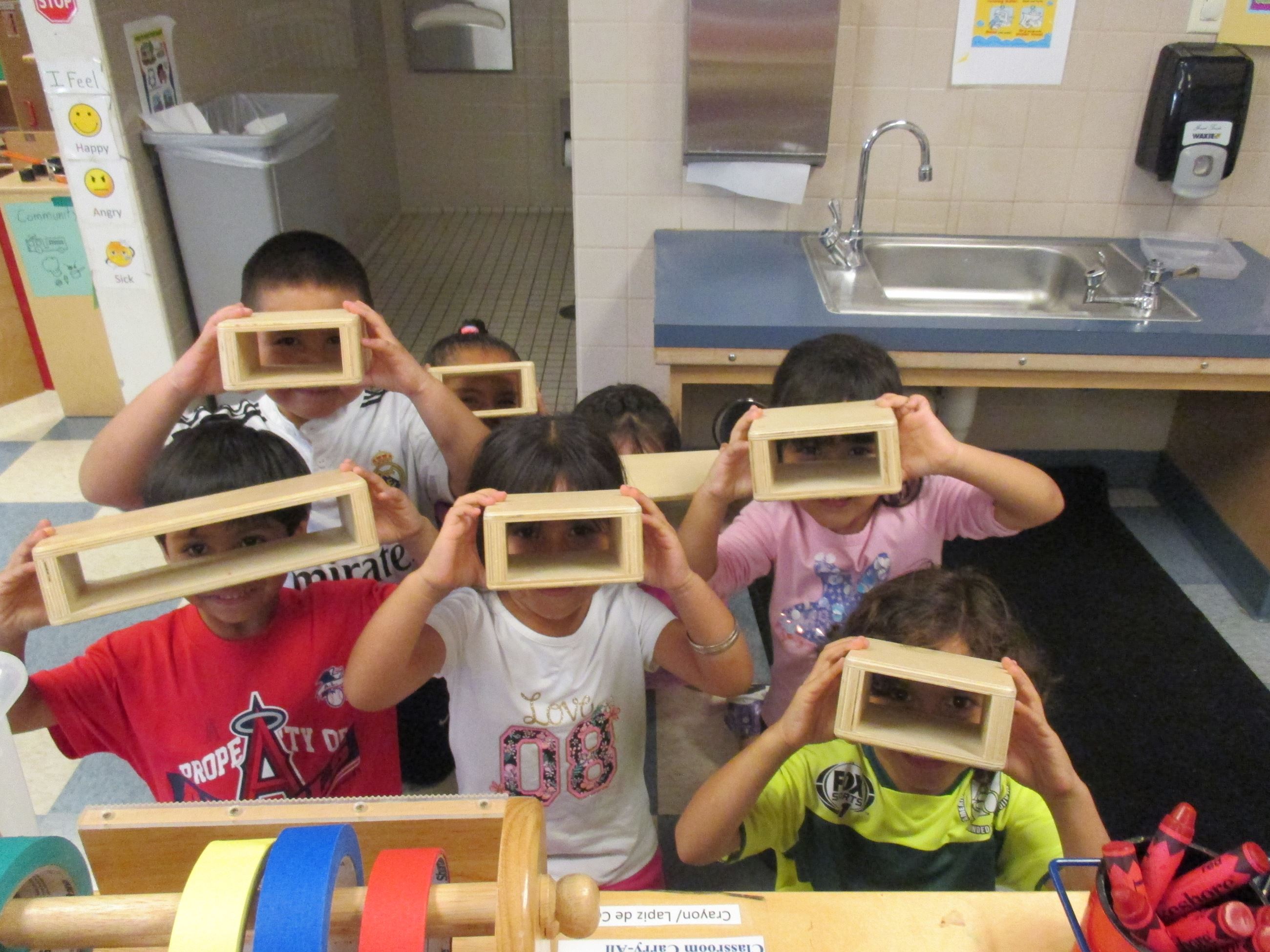 Kids Looking Through Wood Boxes